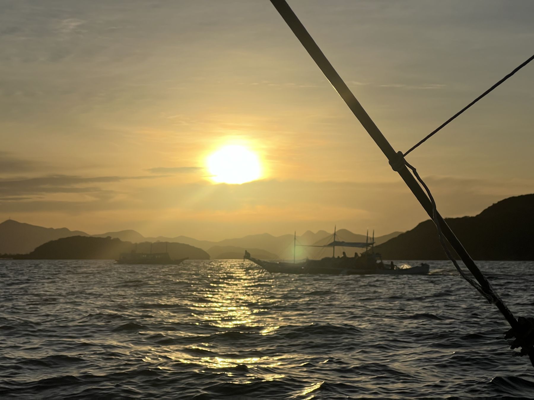 Sunset over the water, boats silhouetted against the horizon, Philippines